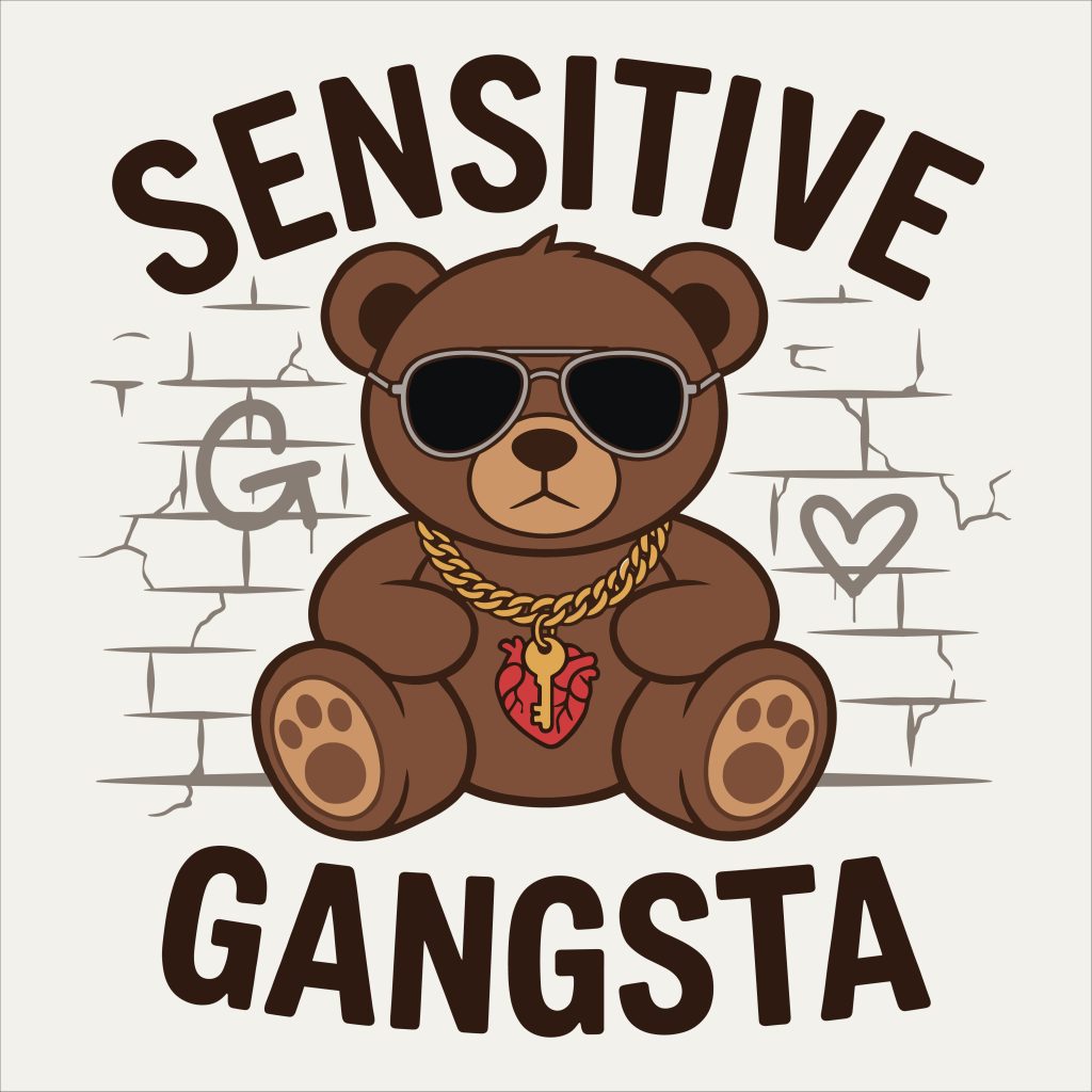 Brown bear wearing aviator sunglasses and a gold heart chain sitting against a graffiti brick wall with the words Sensitive Gangsta
